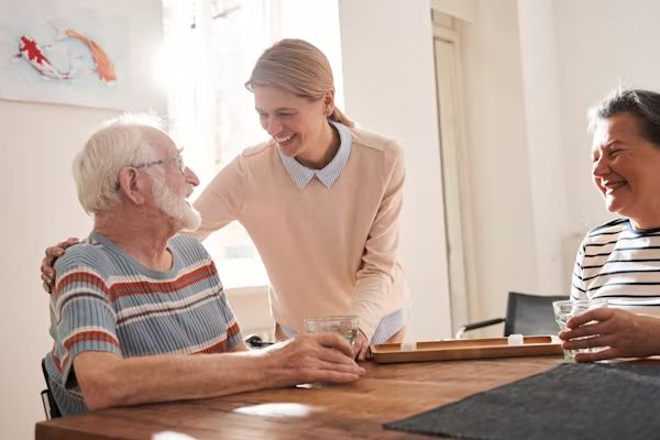 A carer laughing with residents at the table