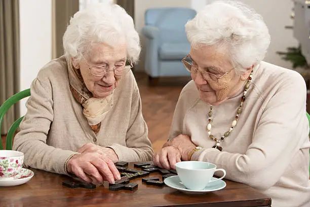 Two residents enjoying a game of dominoes together