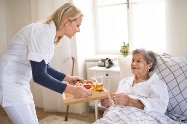 A carer bringing breakfast to a resident